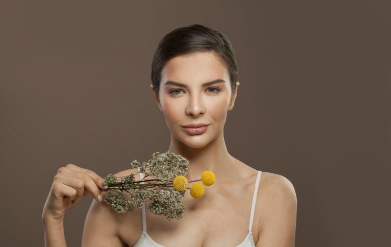 Beautiful female faces on brown background. Facial treatment, herbal medicine and skin care concept Beautiful female faces on brown background. Facial treatment, herbal medicine and skin care concept